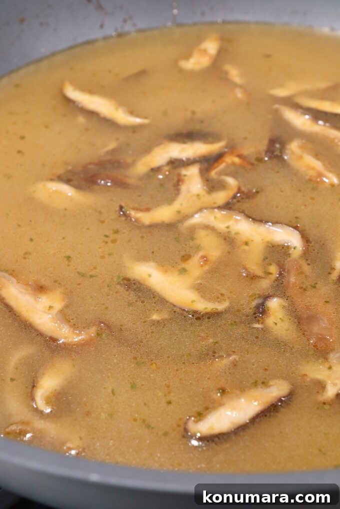 Authentic Miso Ramen Recipe 7 sliced mushrooms in broth in wok