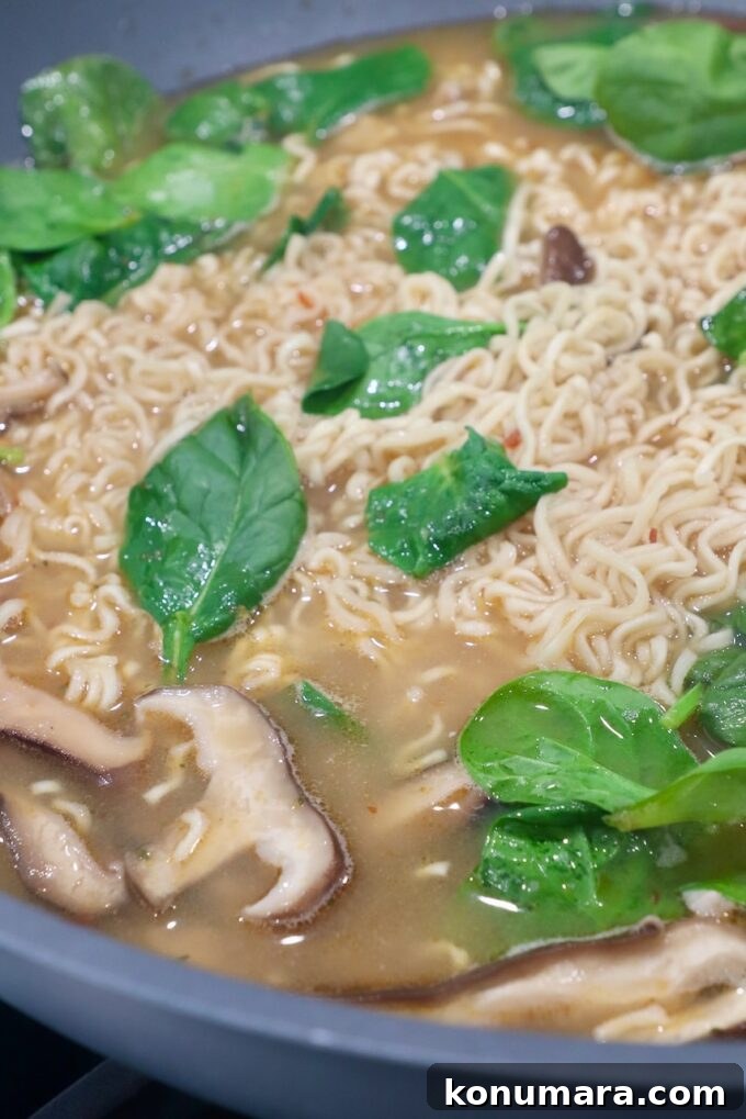 Authentic Miso Ramen Recipe 9 spinach, mushrooms and ramen noodles in broth in wok