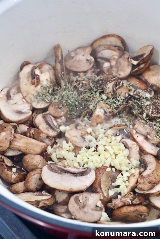 Creamy Garlic Mushroom Pasta Recipe with Parmesan 5 sliced mushrooms in pot with minced garlic, herbs and spices