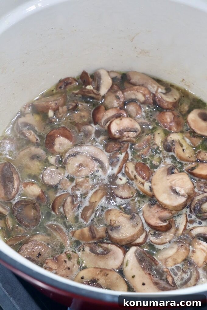 Creamy Garlic Mushroom Pasta Recipe with Parmesan 6 sliced mushrooms with liquid in pot