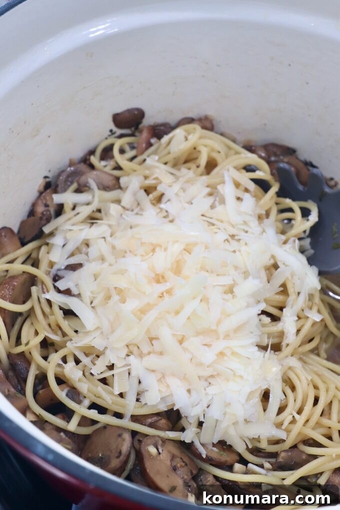 Creamy Garlic Mushroom Pasta Recipe with Parmesan 7 sliced mushrooms in pot with parmesan cheese and cooked spaghetti