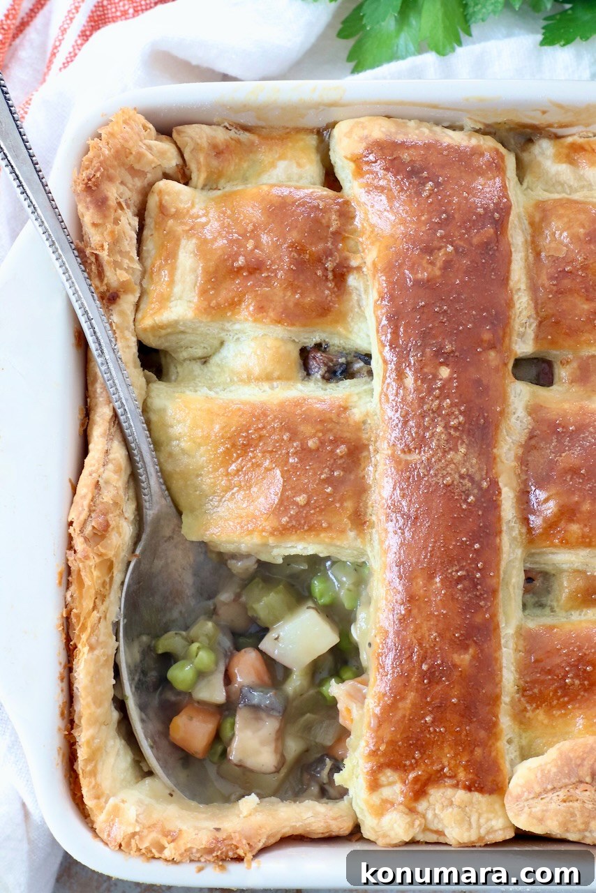 baked vegetable pot pie in square casserole dish with serving spoon
