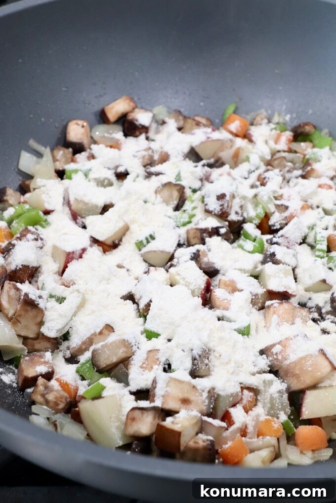 flour sprinkled over diced vegetables in pan