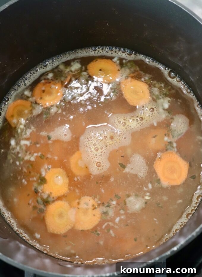 sliced carrots in liquid in pot on the stove
