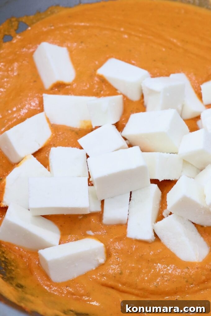 Paneer Makhani: Creamy Indian Butter Paneer Recipe 8 cubes of paneer in pan with curry sauce