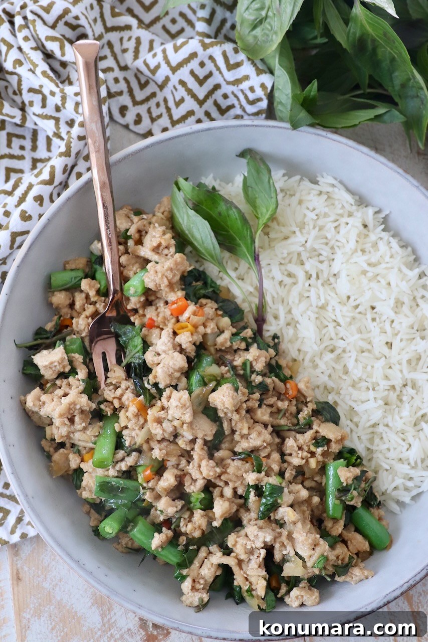 Spicy Thai Basil Chicken (Pad Krapow) Recipe 2 prepared thai basil chicken in bowl with cooked white rice and fresh thai basil leaves