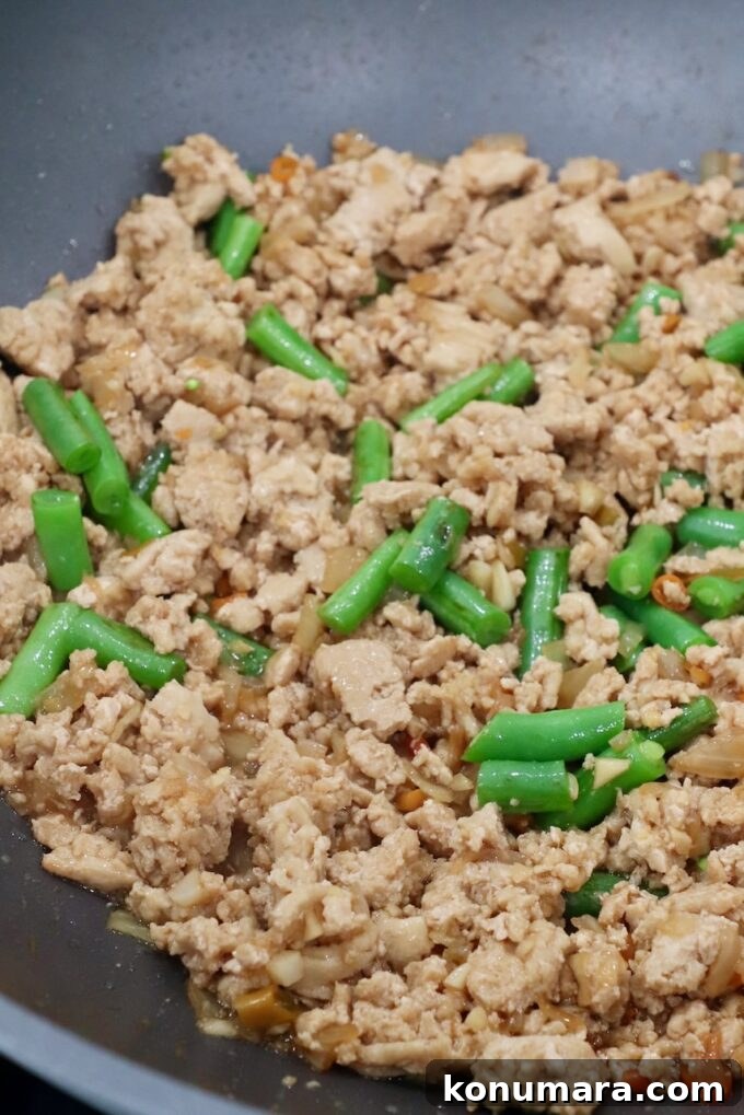 Spicy Thai Basil Chicken (Pad Krapow) Recipe 6 cooked ground chicken with green beans in large pan