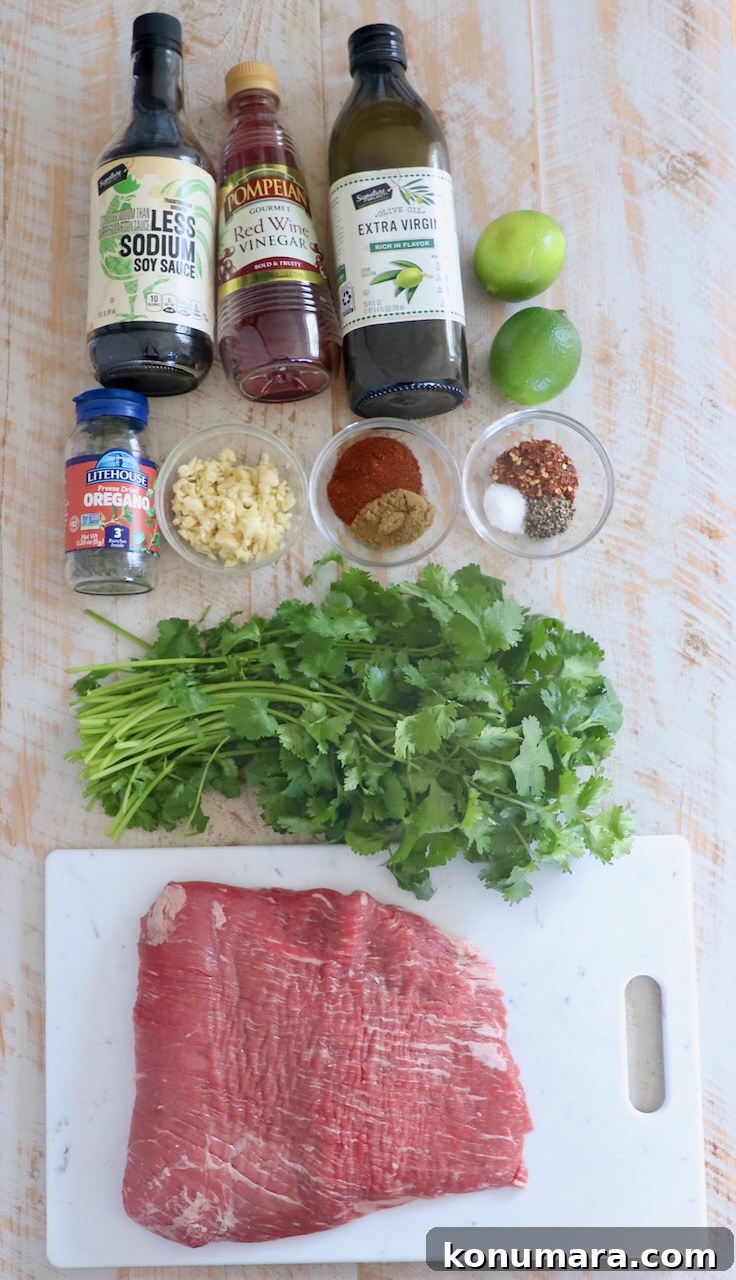 flank steak taco ingredients on white wood board