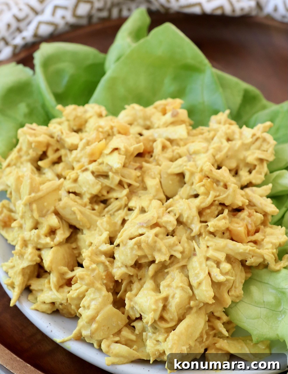 curry chicken salad on top of lettuce leaves on plate