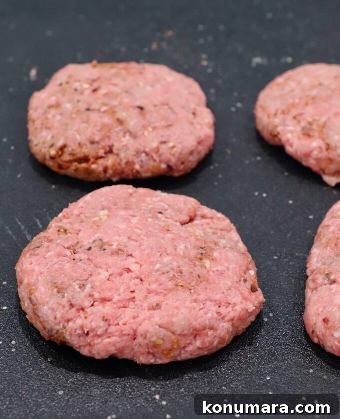 Burger patties on black cutting board