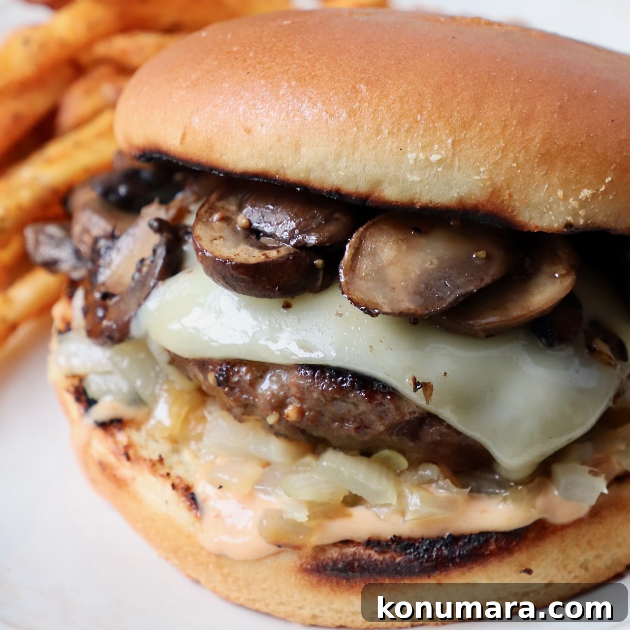 Prepared mushroom swiss burger on plate with fries