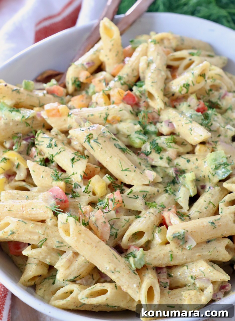 pasta salad tossed with creamy dressing in large bowl