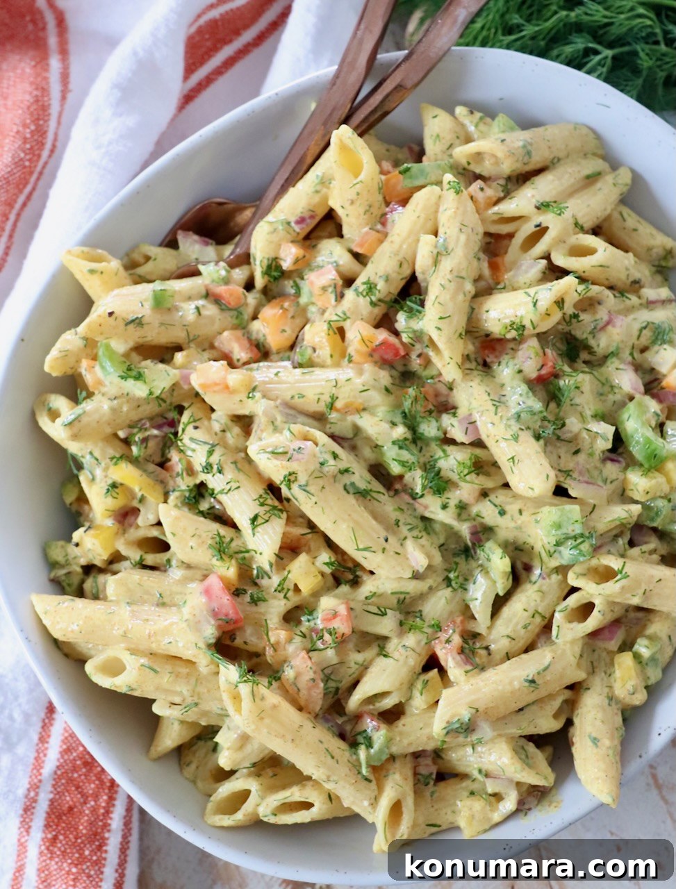 creamy curry pasta salad in bowl with forks