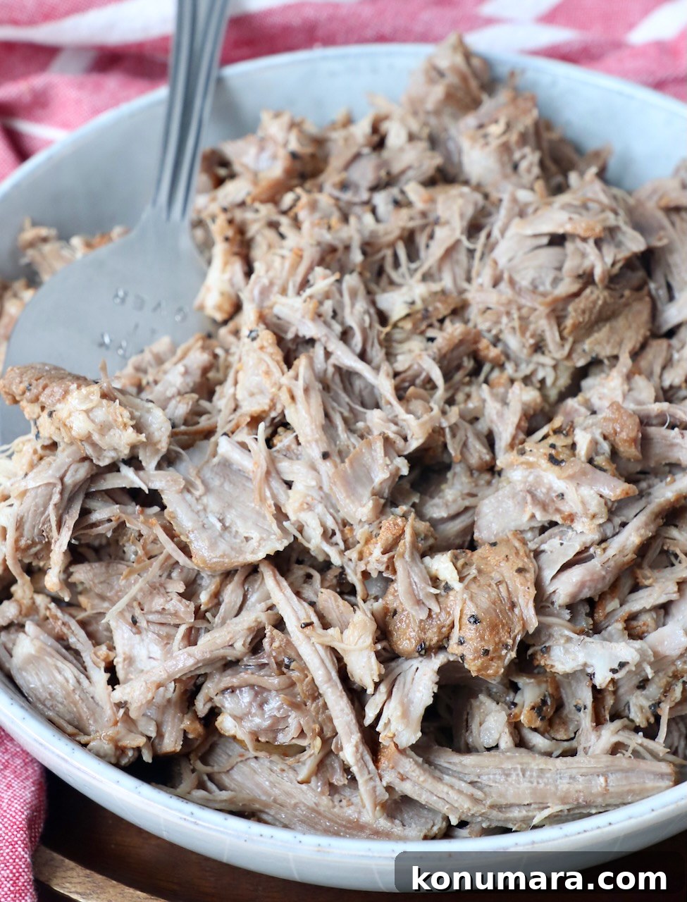Tender and Juicy Instant Pot Pulled Pork Recipe 7 pulled pork in a bowl with large serving fork
