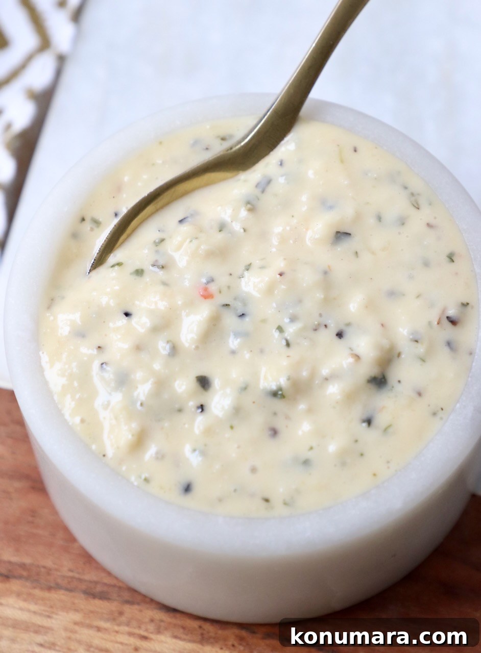 Creamy Garlic Parmesan Sauce Recipe 2 garlic parmesan sauce in small bowl with gold spoon