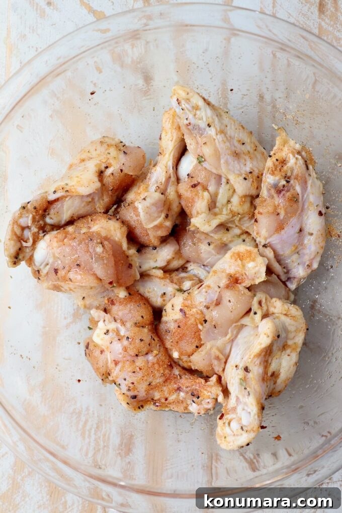 seasoned chicken wings in glass bowl