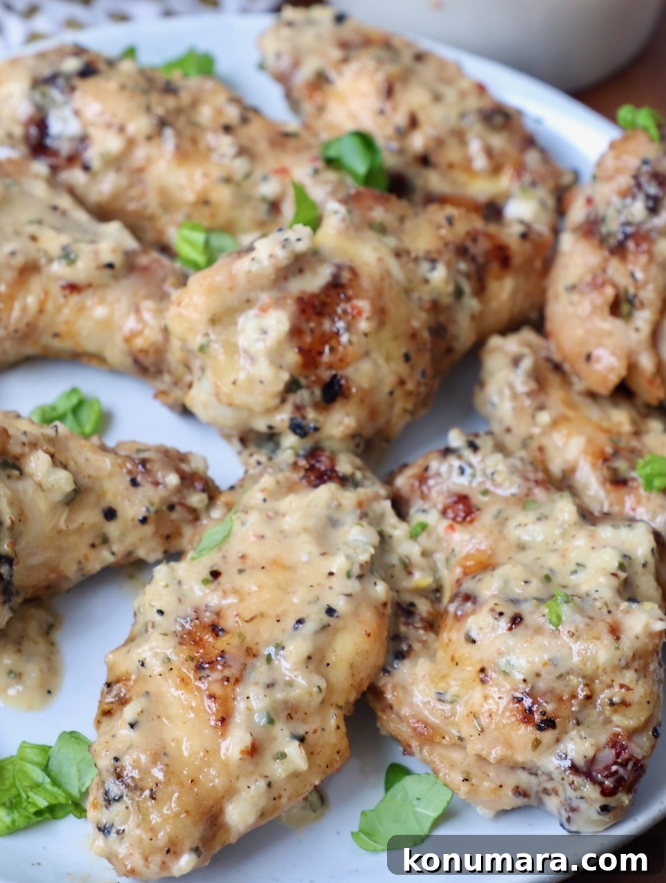 grilled chicken wings tossed in garlic parmesan sauce on plate