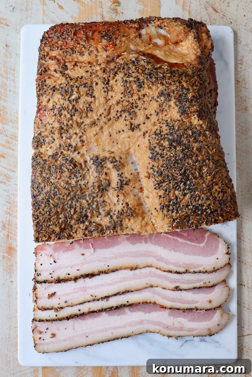 homemade bacon partly sliced on cutting board