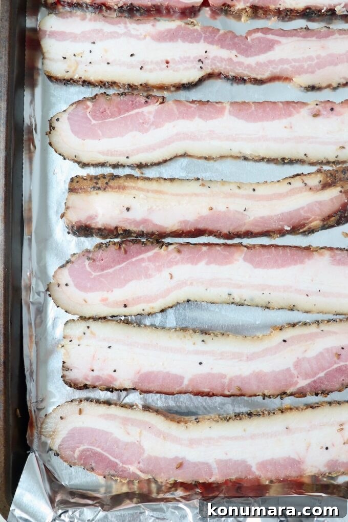 sliced bacon on foil-lined baking sheet