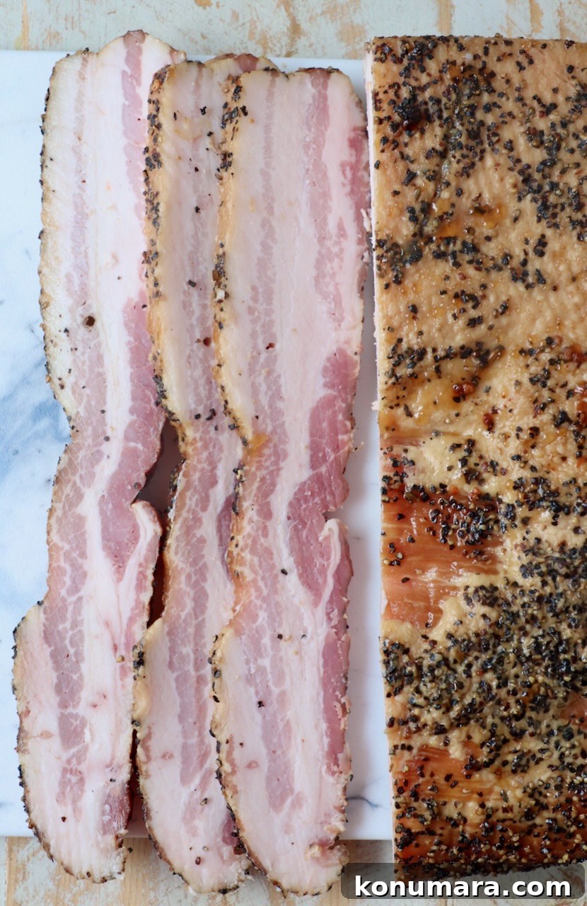 sliced bacon from a smoked pork belly on cutting board