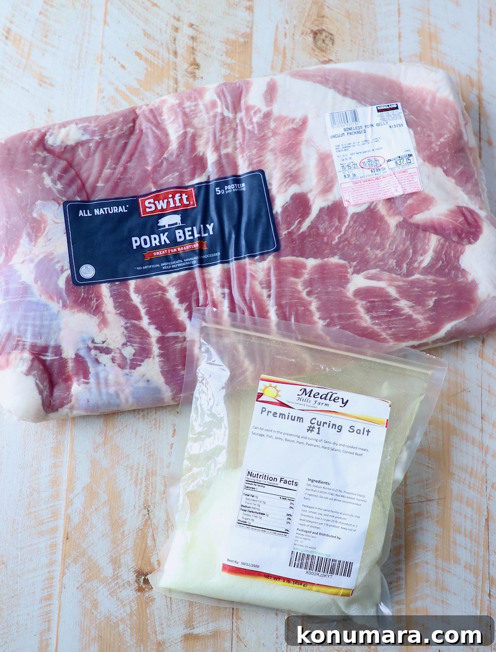pork belly and curing salt on white wood board