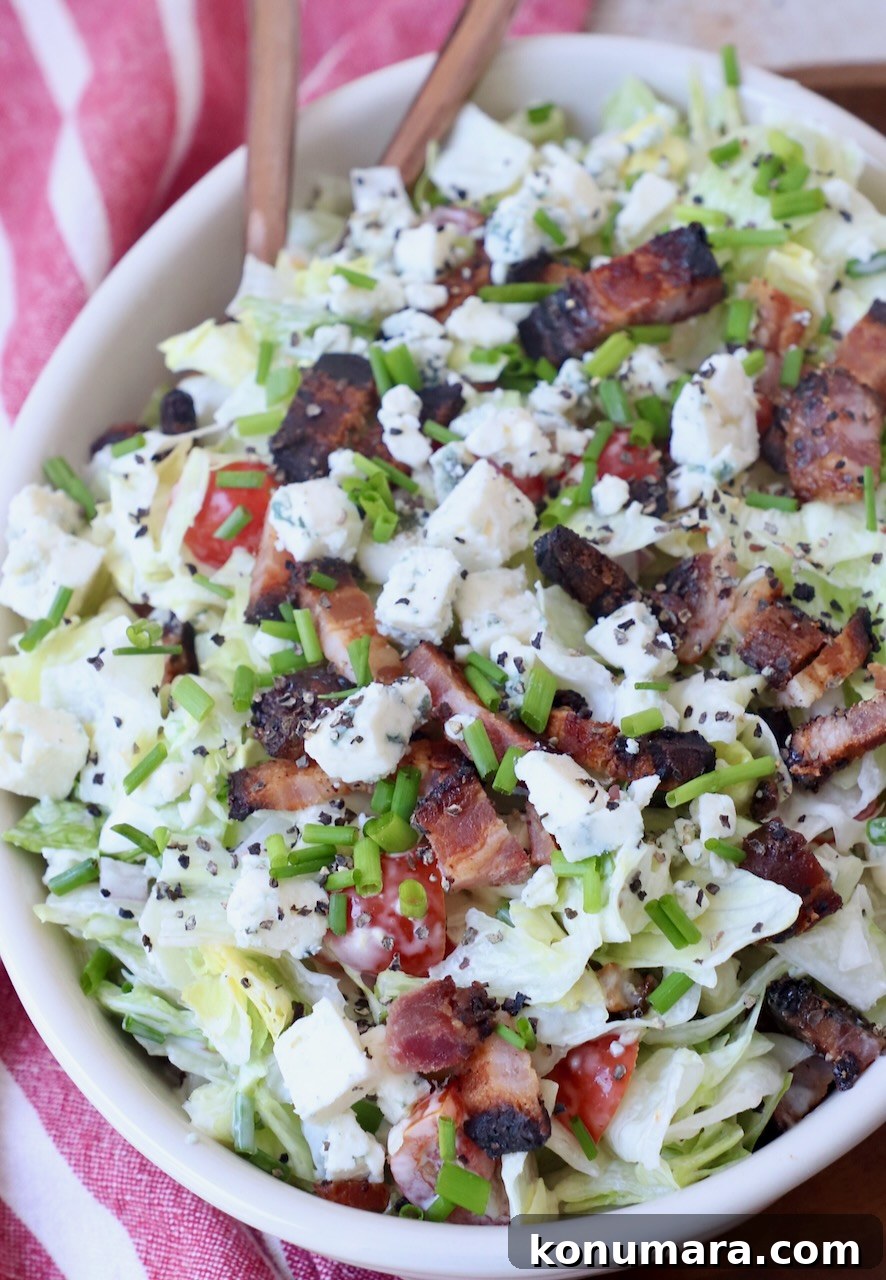 Creamy Blue Cheese Salad Recipe with Tangy Dressing 2 chopped blue cheese salad topped with chopped bacon in bowl with spoon