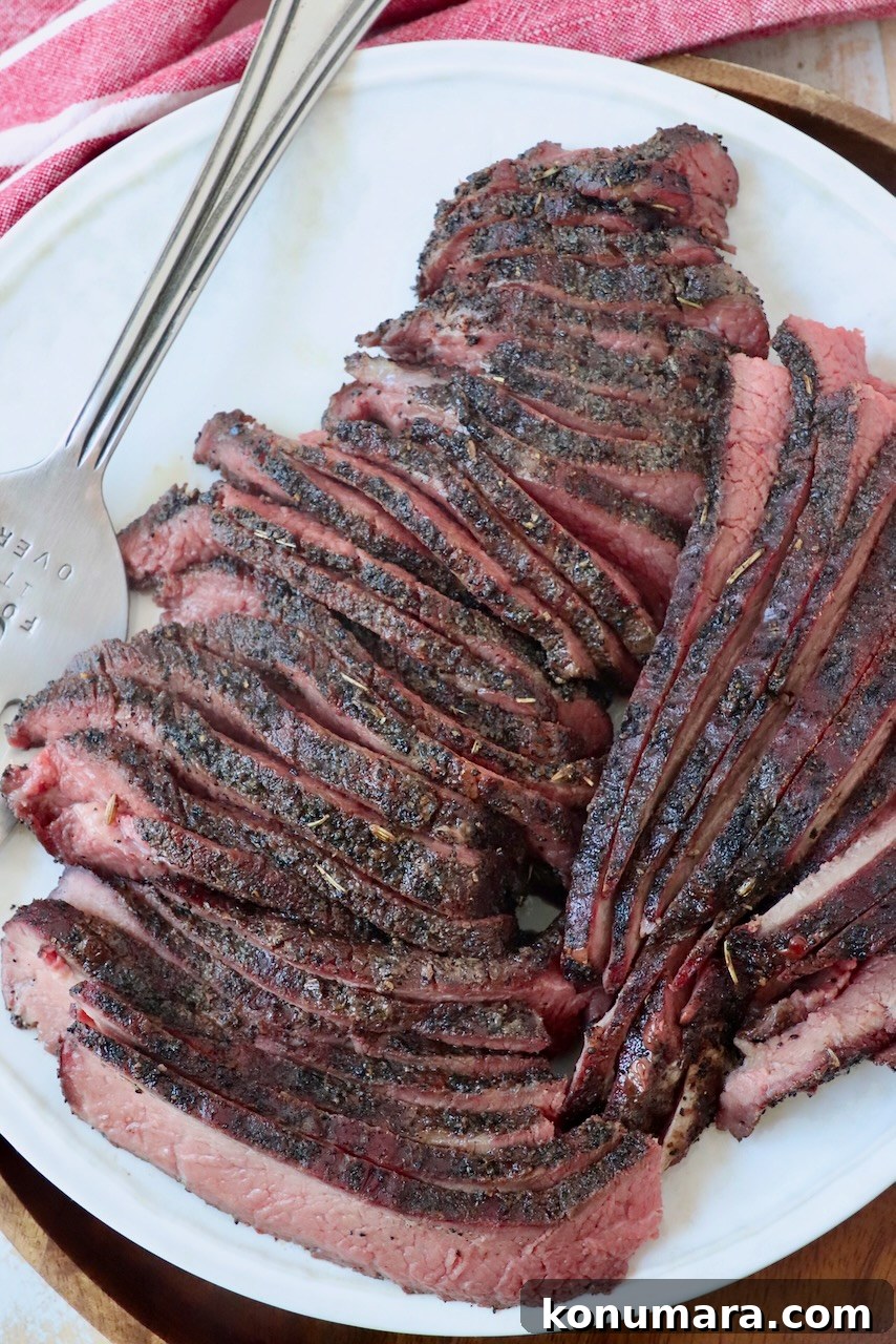 sliced coffee crusted smoked tri tip on plate with serving fork