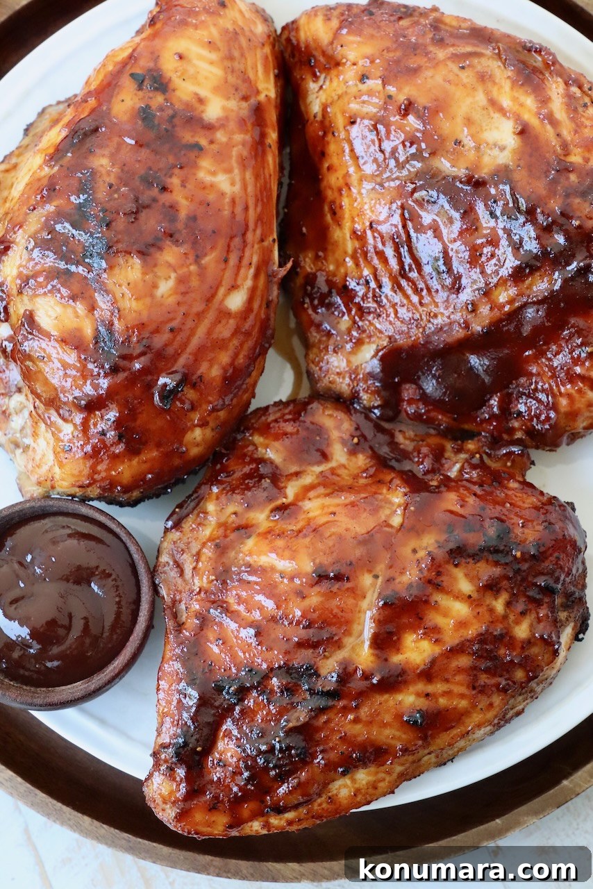 Juicy BBQ Chicken Recipe with Smoky Barbecue Sauce 7 grilled chicken breasts on plate covered with bbq sauce