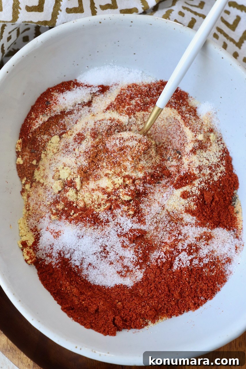 spices mixed together in a bowl with a small spoon