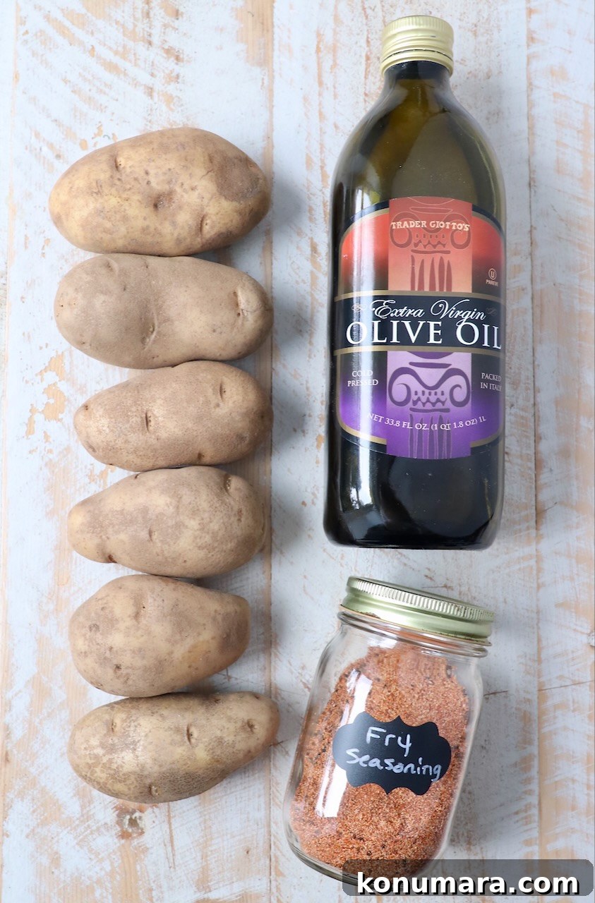 ingredients for homemade french fries on white wood board