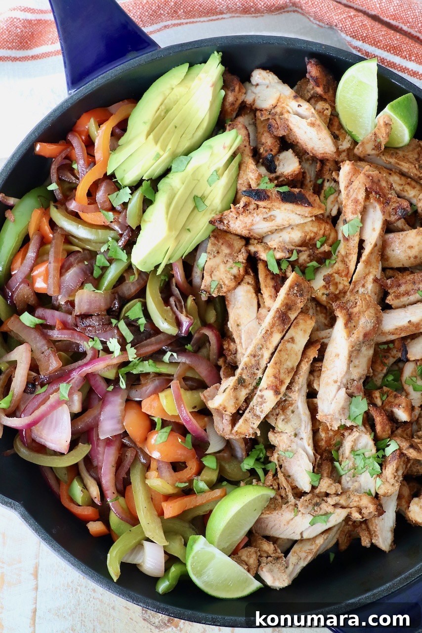 grilled chicken and vegetables in skillet with sliced avocado and lime wedges