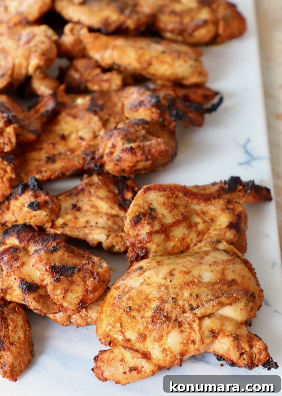 grilled chicken thighs on white cutting board
