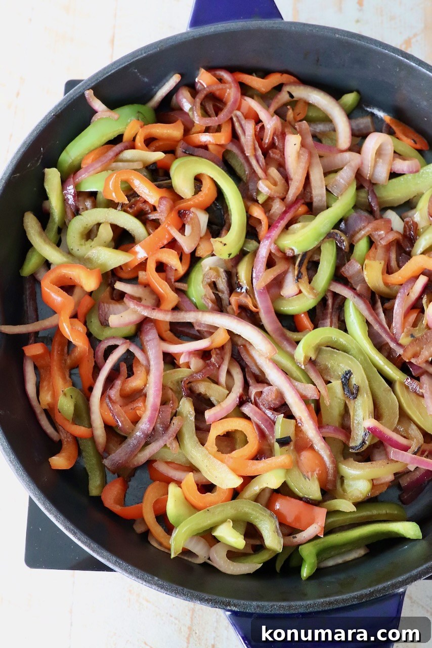 cooked sliced bell peppers and onions in large skillet