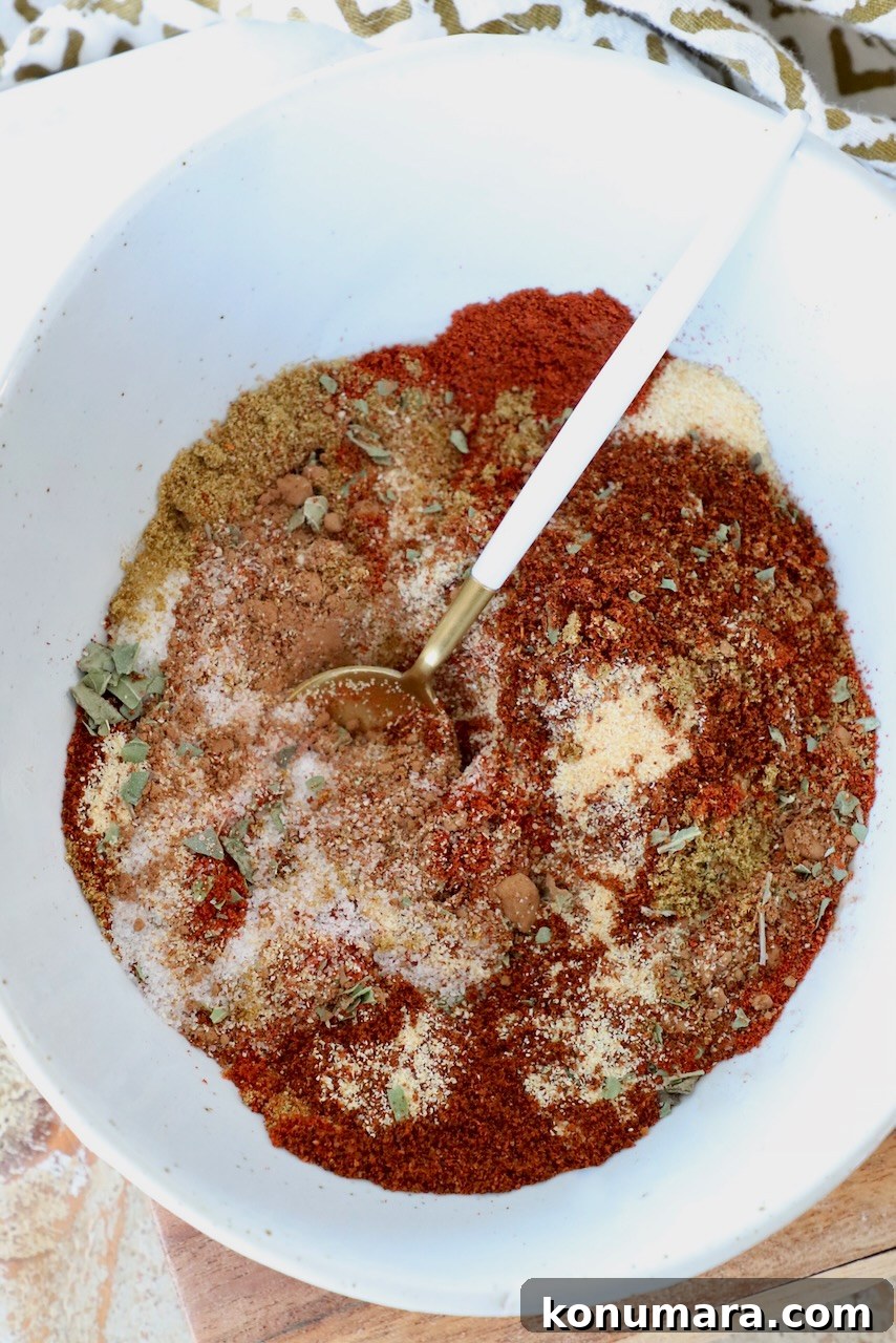 spices and herbs mixed together in a bowl with spoon