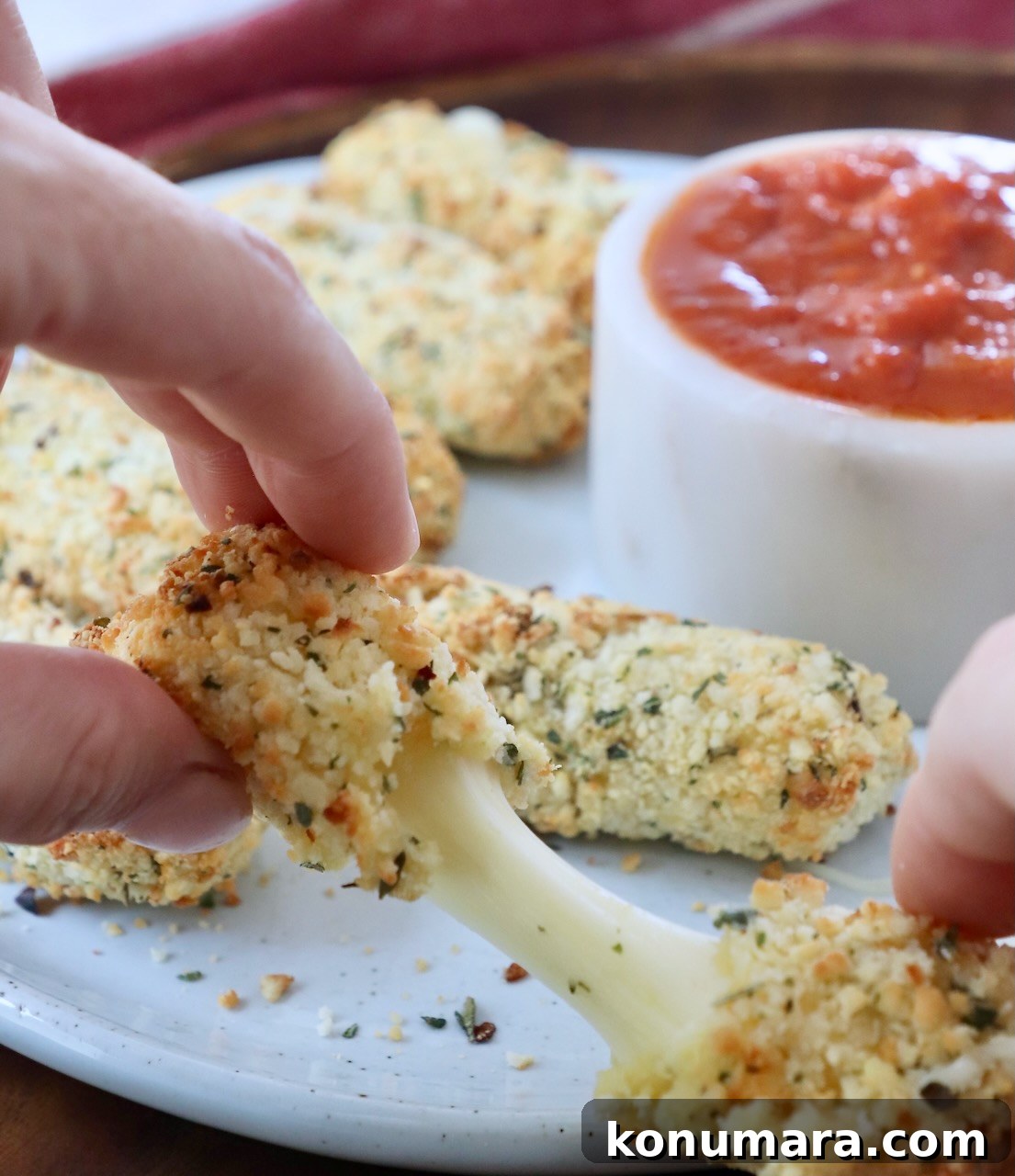 mozzarella stick being pulled in half by hands