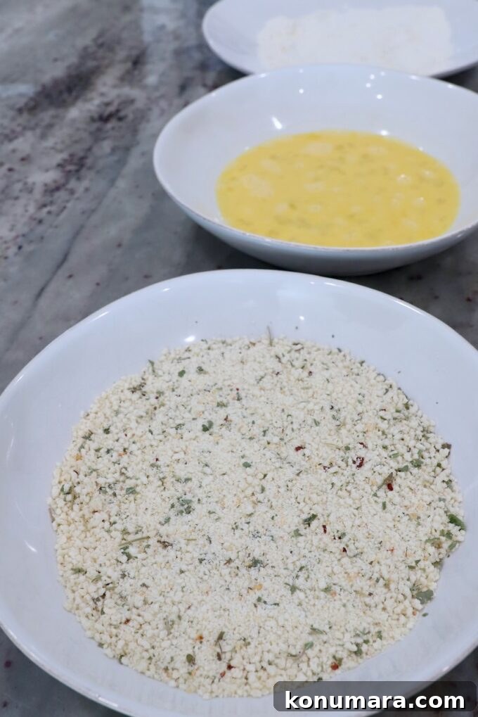 seasoned breadcrumbs in bowl, whisked eggs in another bowl and flour in another bowl on countertop