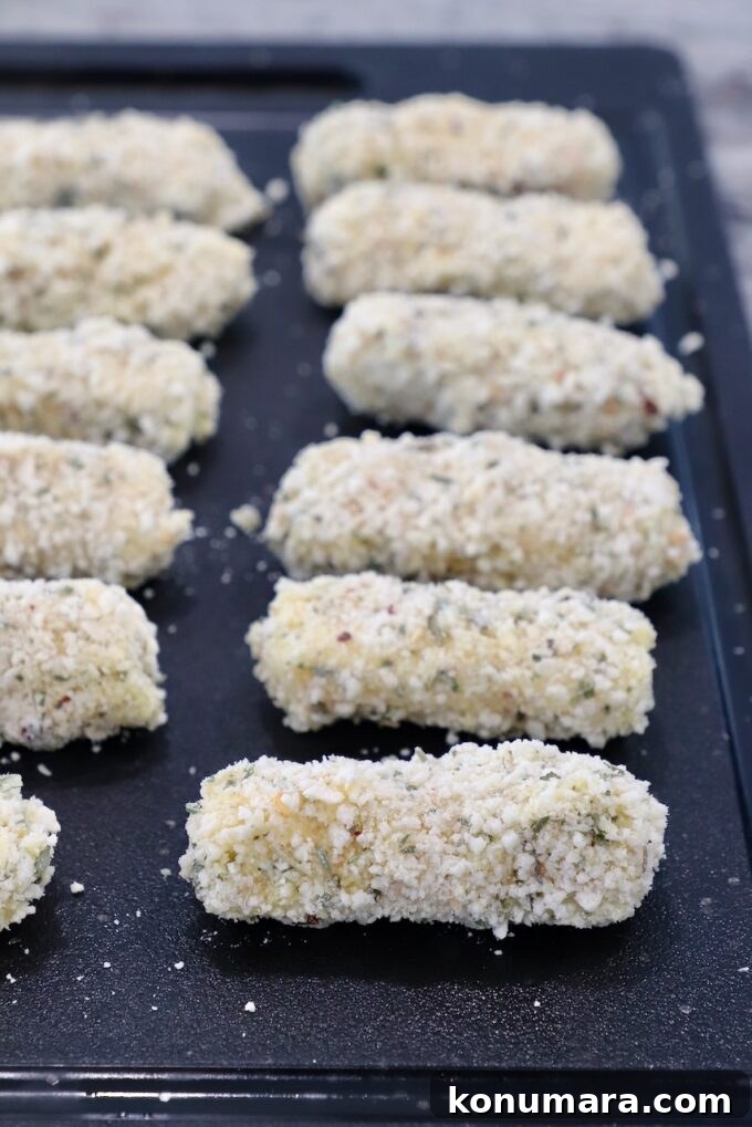 breaded mozzarella sticks on cutting board