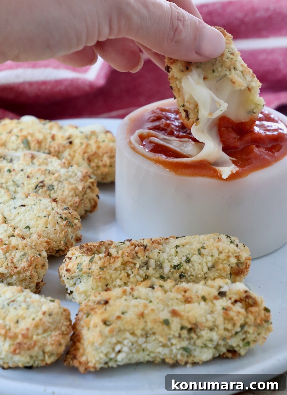 mozzarella sticks on plate and dipped into bowl of marinara sauce
