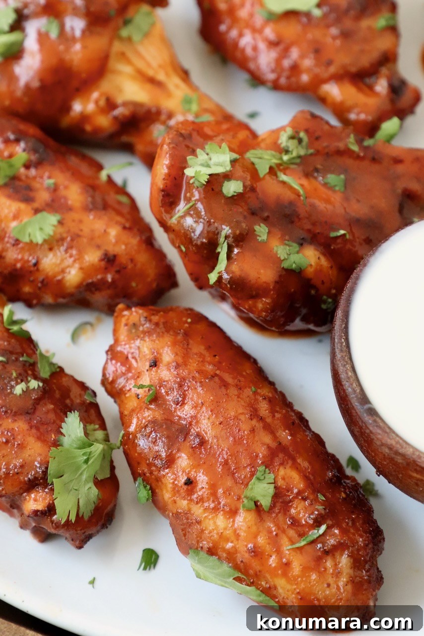 Smoked Chicken Wings: Crispy, Tender and Flavorful 2 smoked chicken wings tossed in buffalo sauce on plate