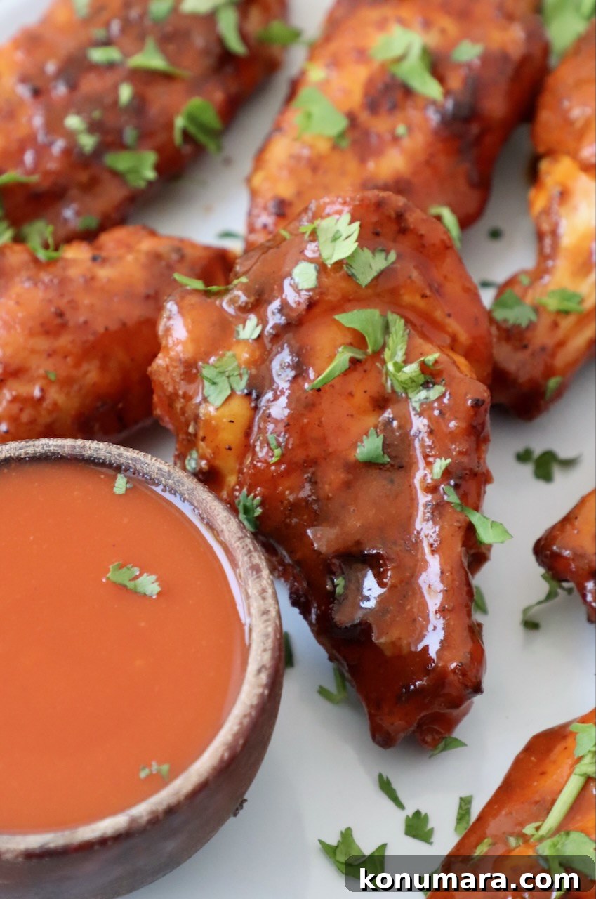 Smoked Chicken Wings: Crispy, Tender and Flavorful 9 cooked chicken wings tossed in buffalo sauce on plate