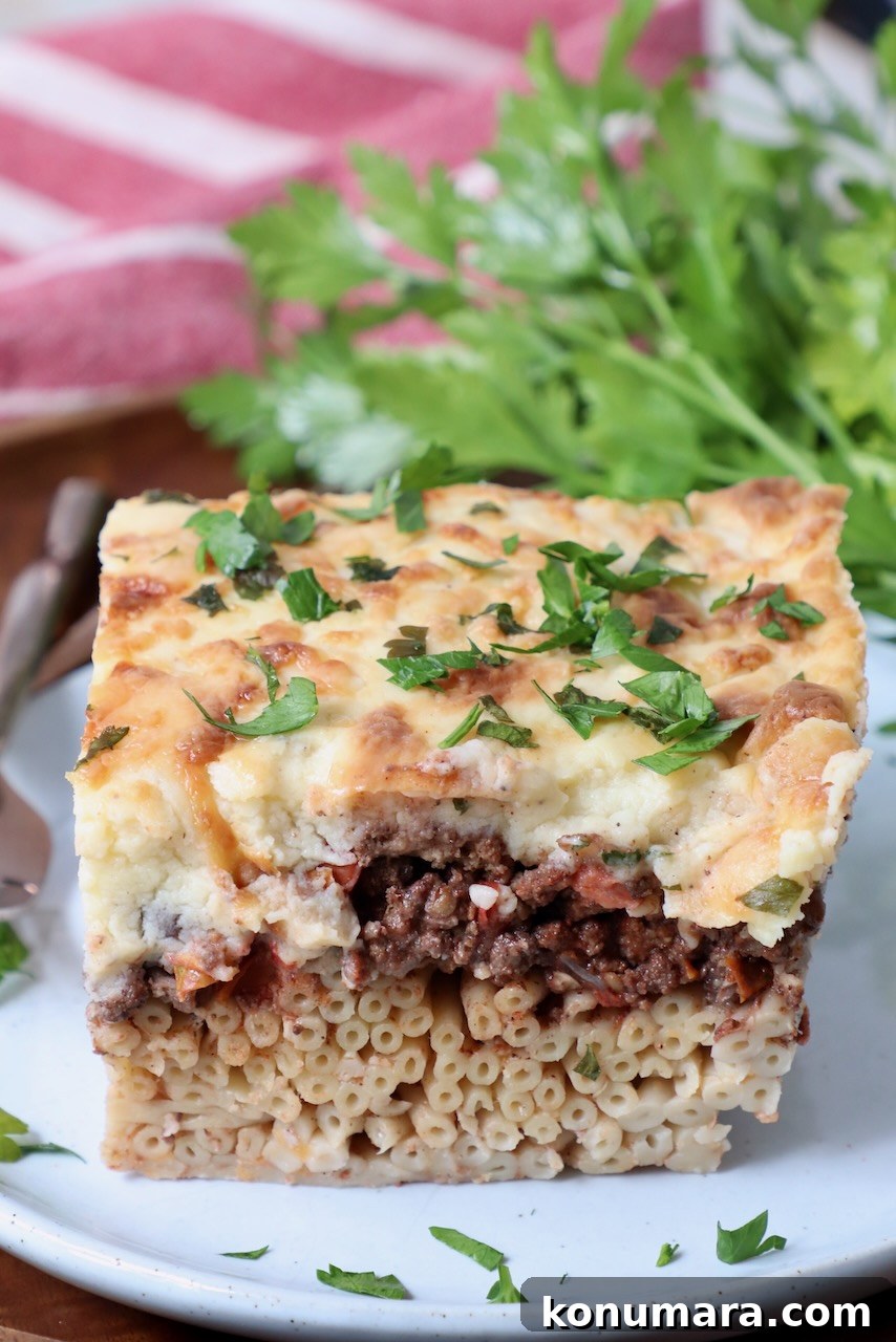 slice of pastitsio on plate with fresh parsley