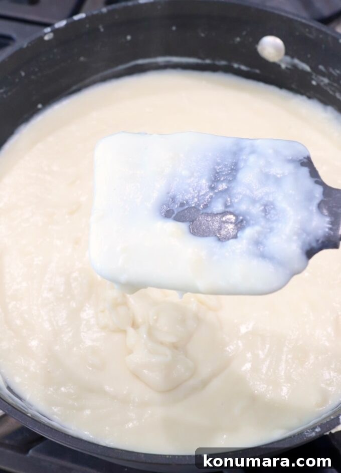 creamy bechamel sauce in skillet with spatula