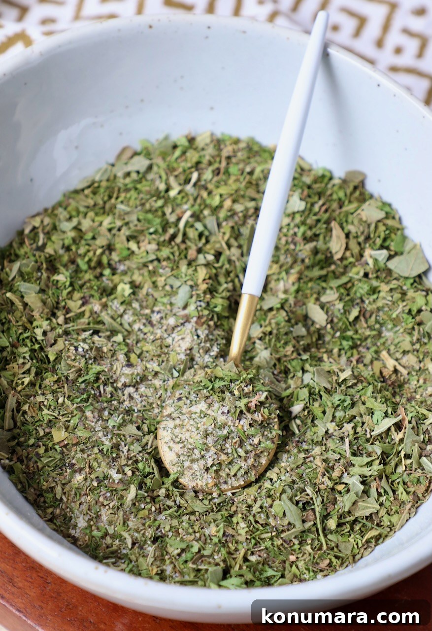 Greek seasoning combined in a bowl with a small spoon