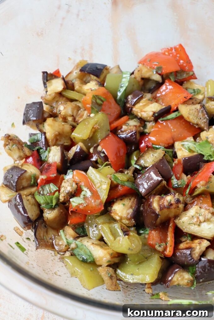 Smoky Grilled Eggplant Salad with Lemon and Herbs 5 roasted eggplants and bell peppers tossed with balsamic dressing in large glass bowl
