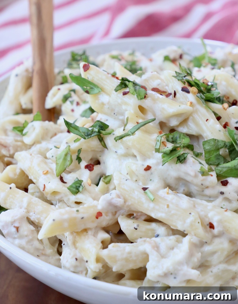 Creamy Garlic Parmesan Chicken Pasta Recipe 9 pasta tossed with creamy sauce in bowl with serving spoon