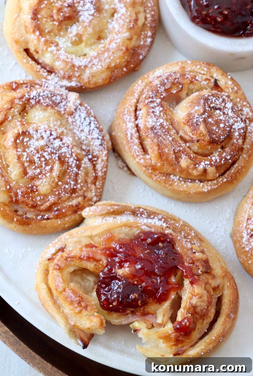 Monte Cristo rolls topped with raspberry jam on a plate