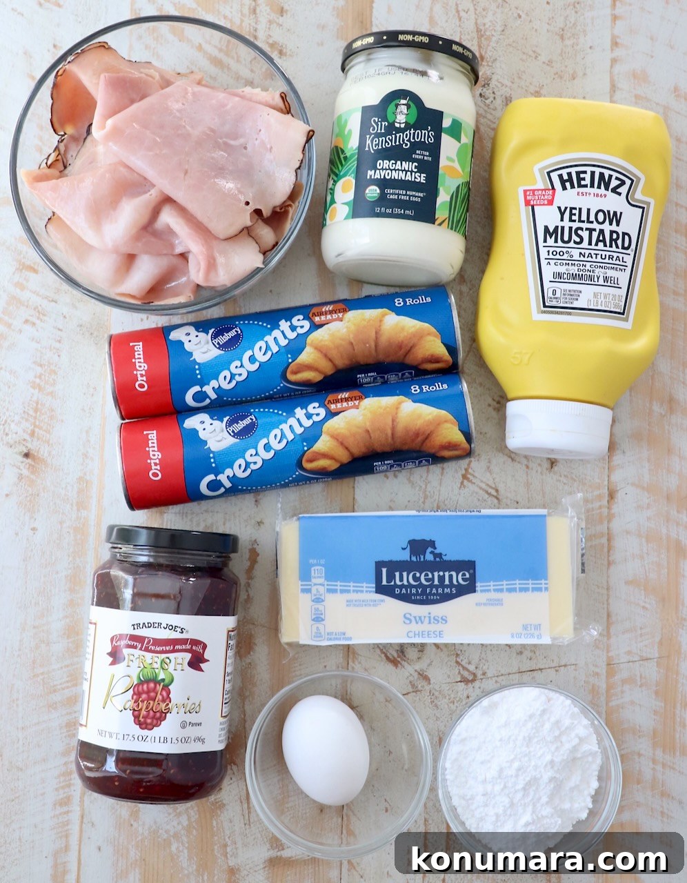 Ingredients for Monte Cristo rolls on a white wood board