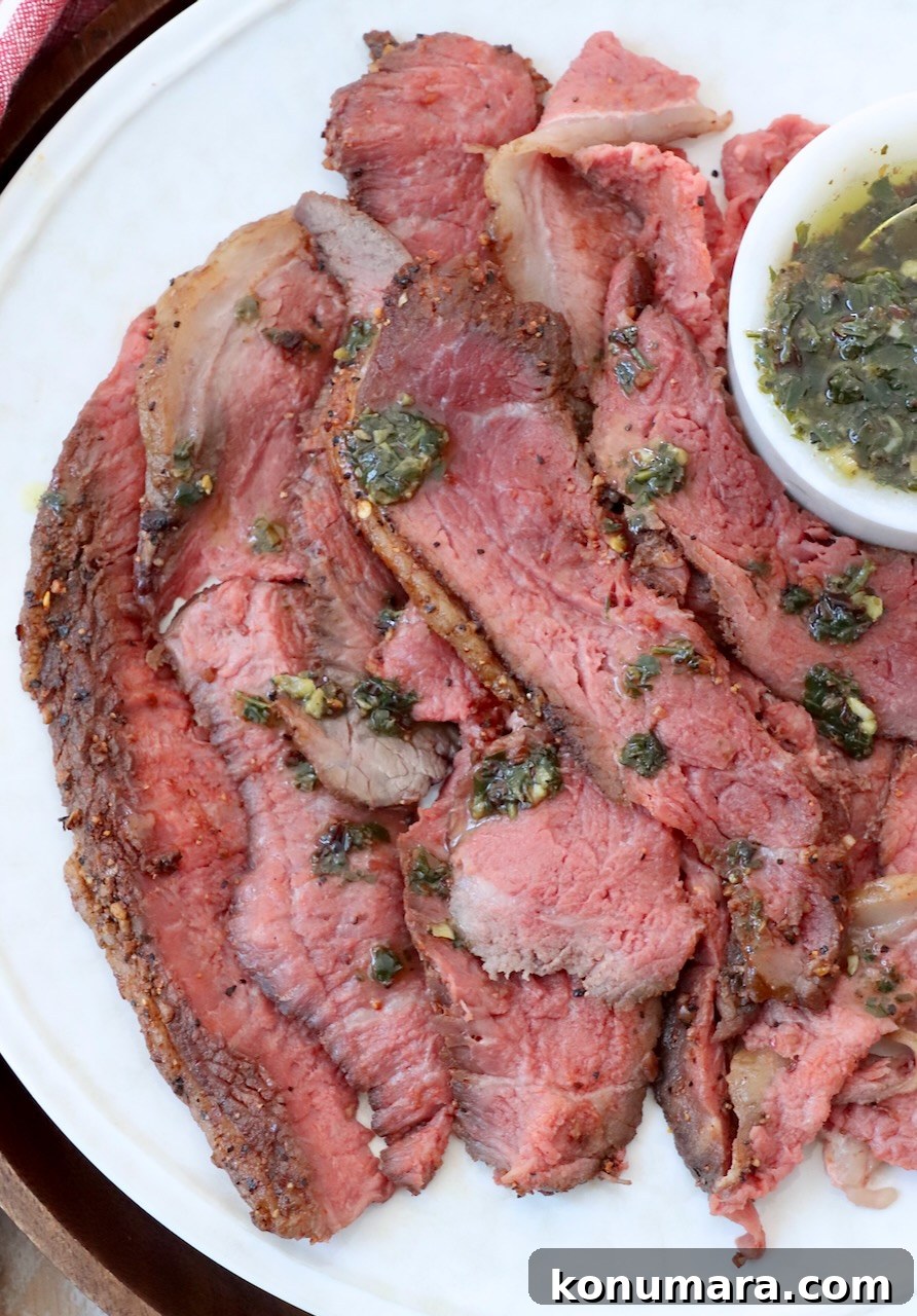 Rotisserie Picanha Recipe: Juicy Brazilian Rump Cap on the Spit 14 thinly sliced cooked steak on plate with herb sauce