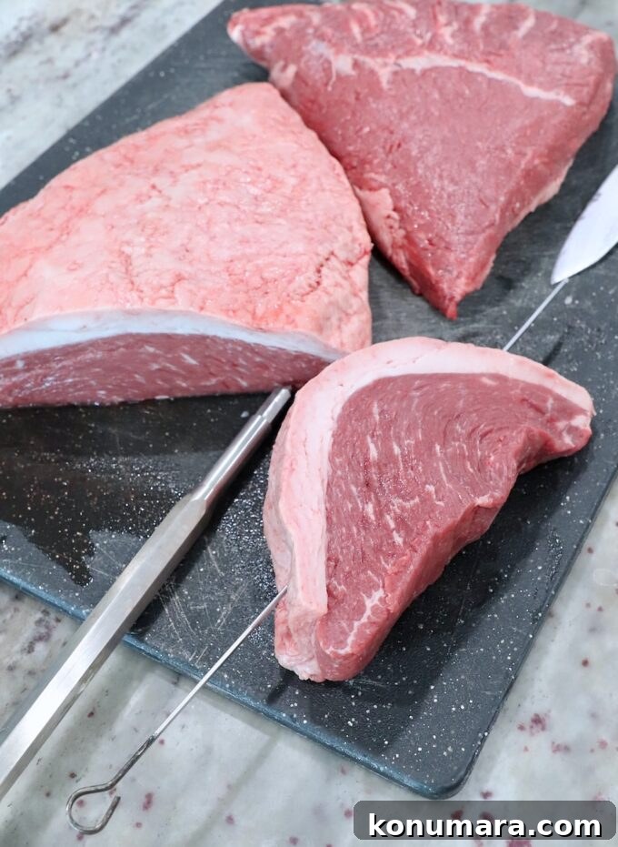 Rotisserie Picanha Recipe: Juicy Brazilian Rump Cap on the Spit 4 piece of steak with a metal skewer through the steak
