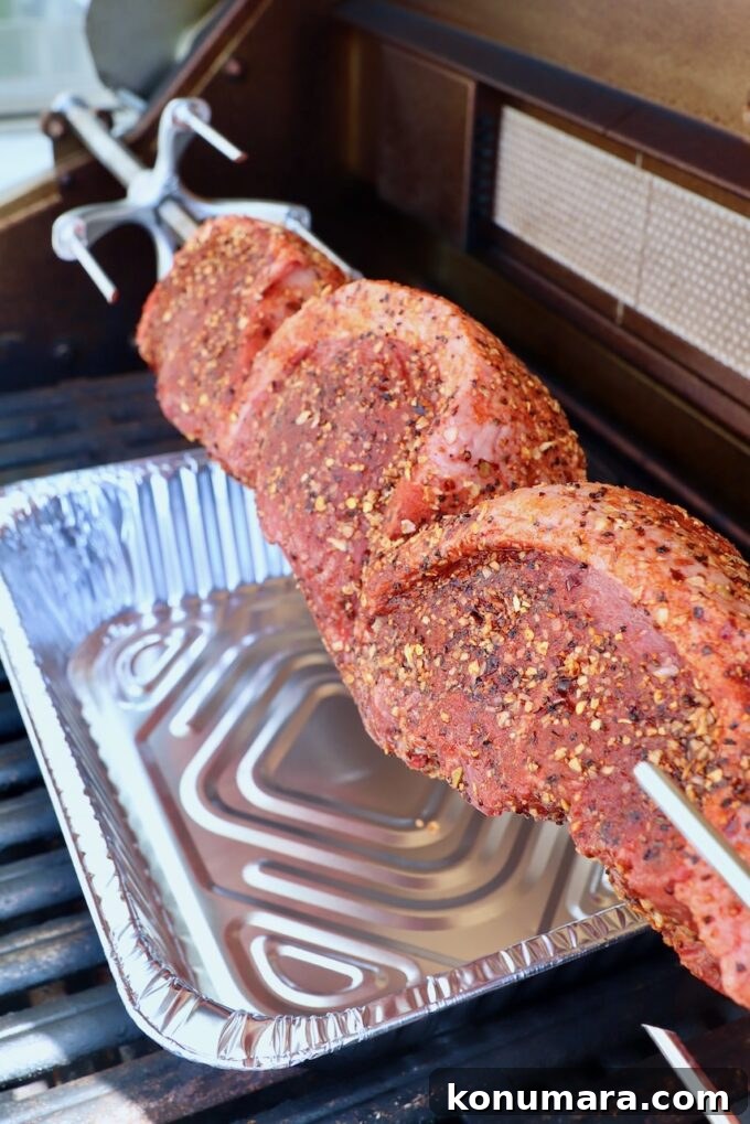 Rotisserie Picanha Recipe: Juicy Brazilian Rump Cap on the Spit 8 uncooked steaks on a rotisserie rod in a grill